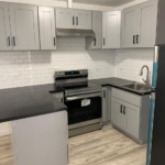 View of the Kitchen from the hallway showcasing the refrigerator, range and rangehood and pennisula/breakfast bar in San Gil Apartments Unit 4